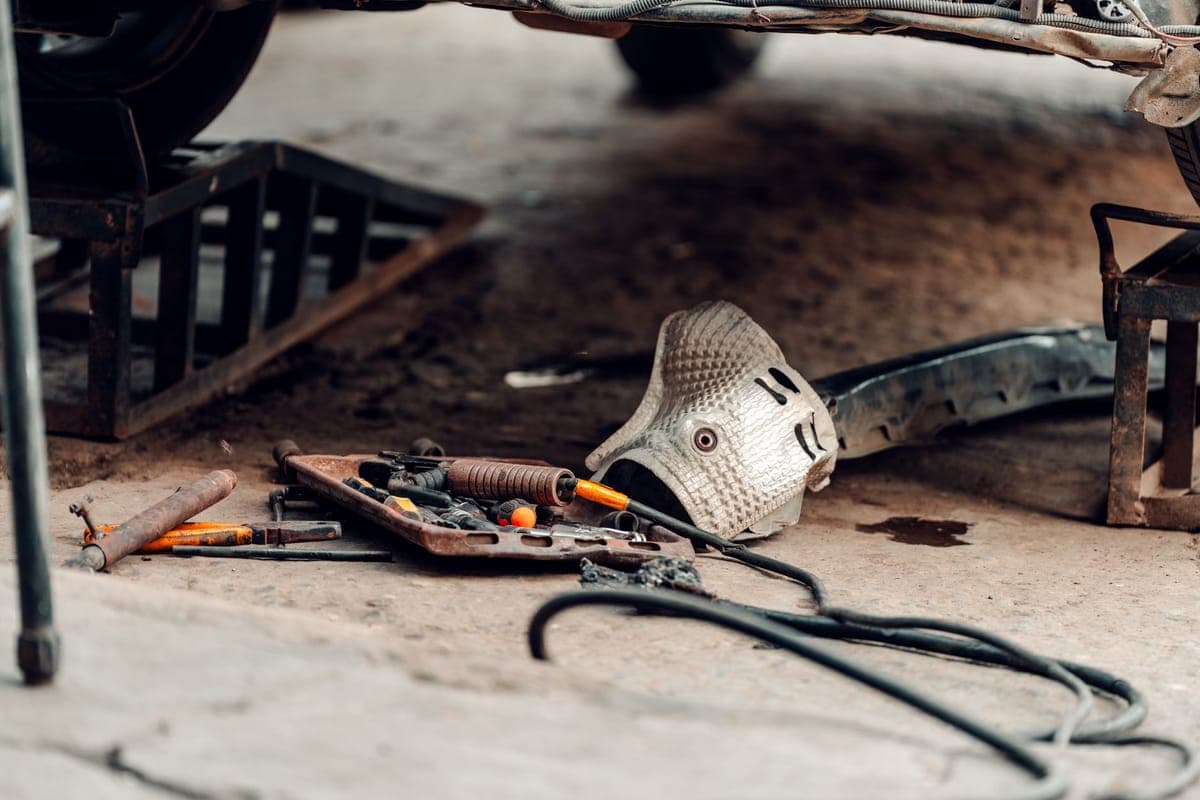 Disassembled prop sections and hardware laid out on a garage floor