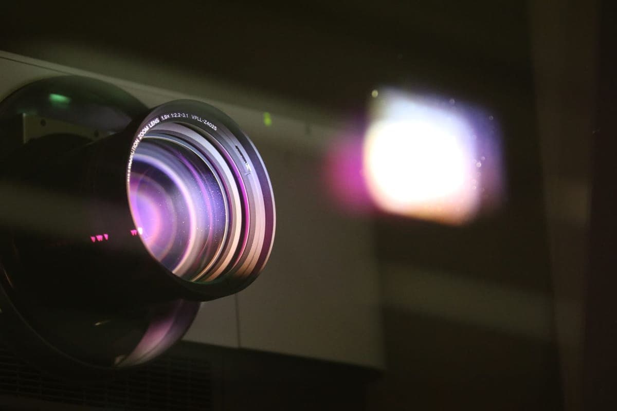 A projected figure on a window screen beside a patterned facade projection