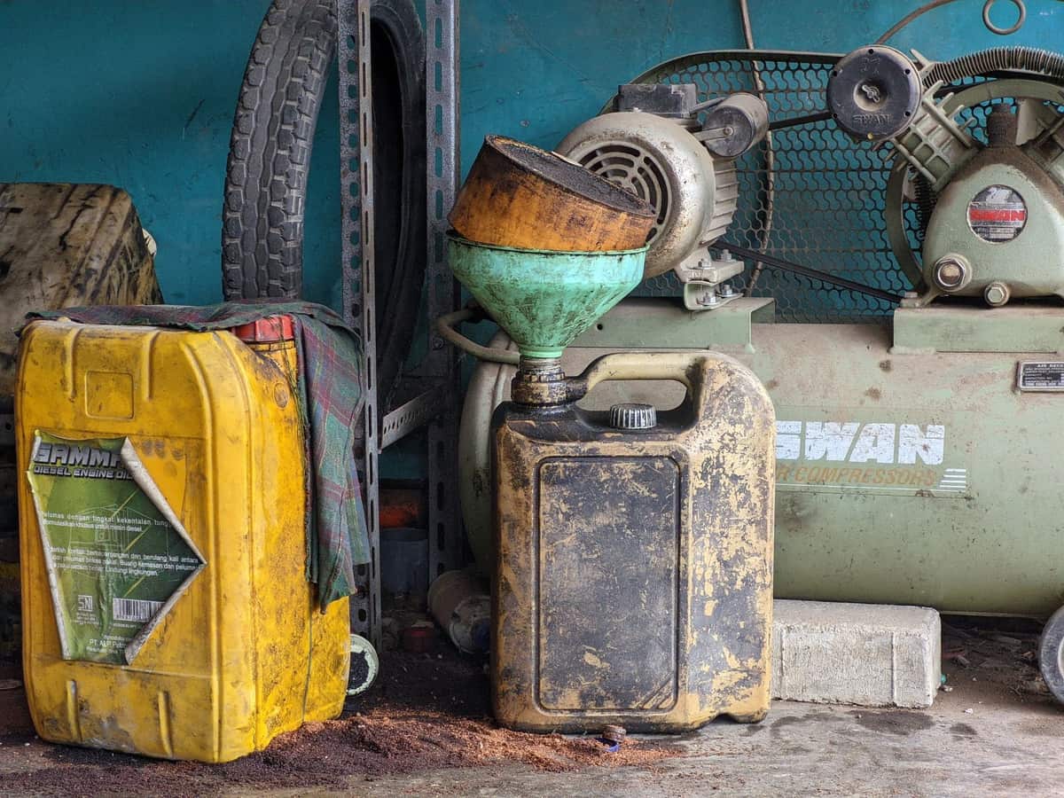 Containers of fog fluid on a workbench beside a fog machine