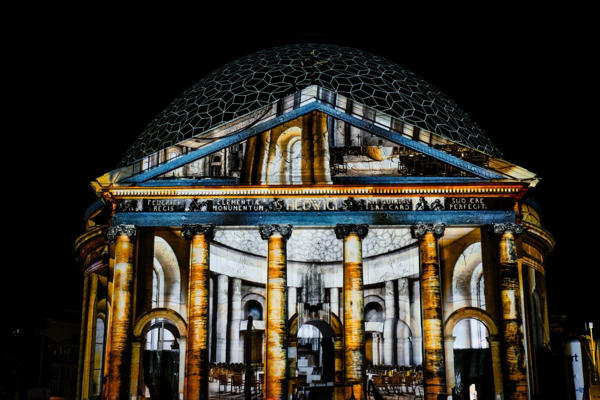 A scene projected across the front of a house on a dark evening