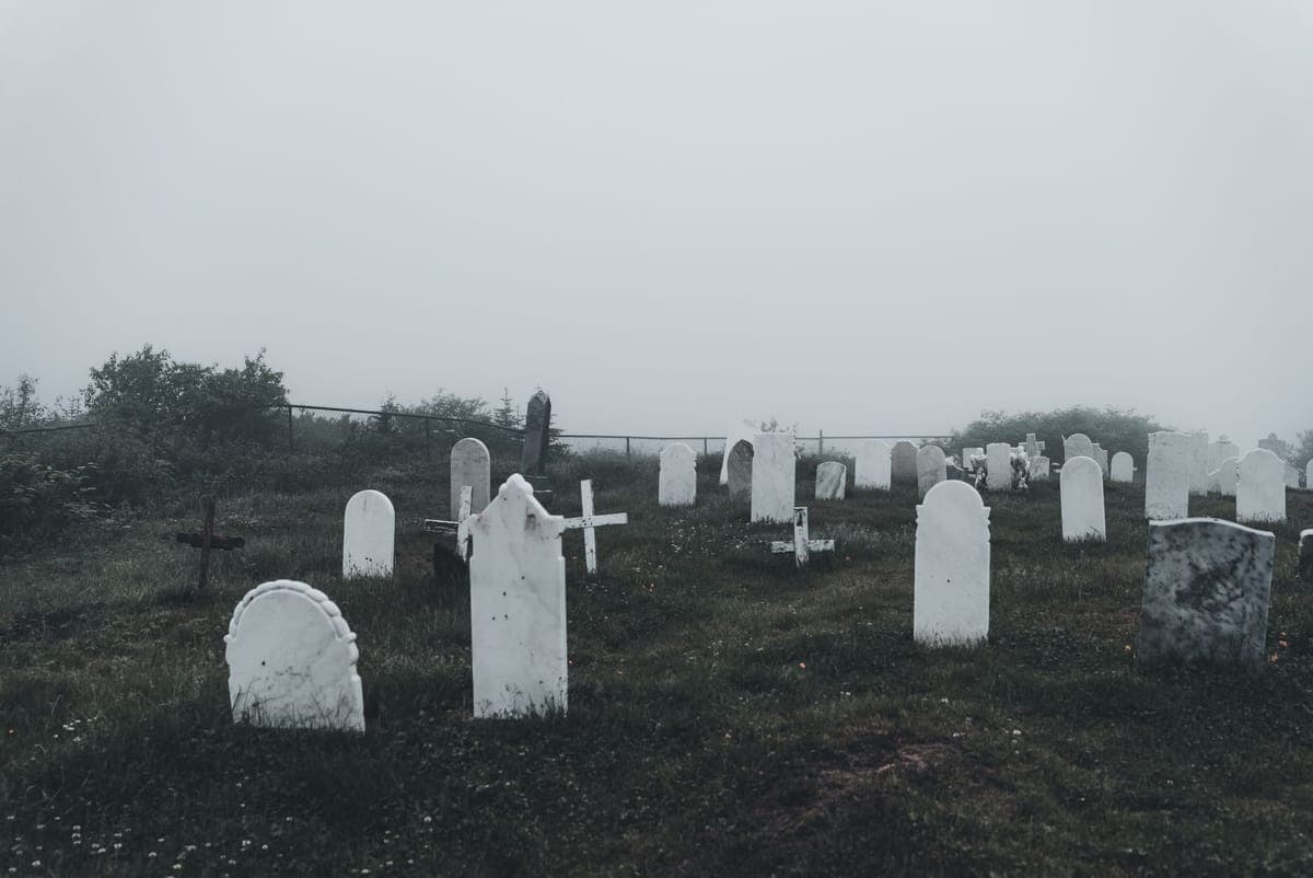 Ground-hugging fog spreading between gravestone props at night
