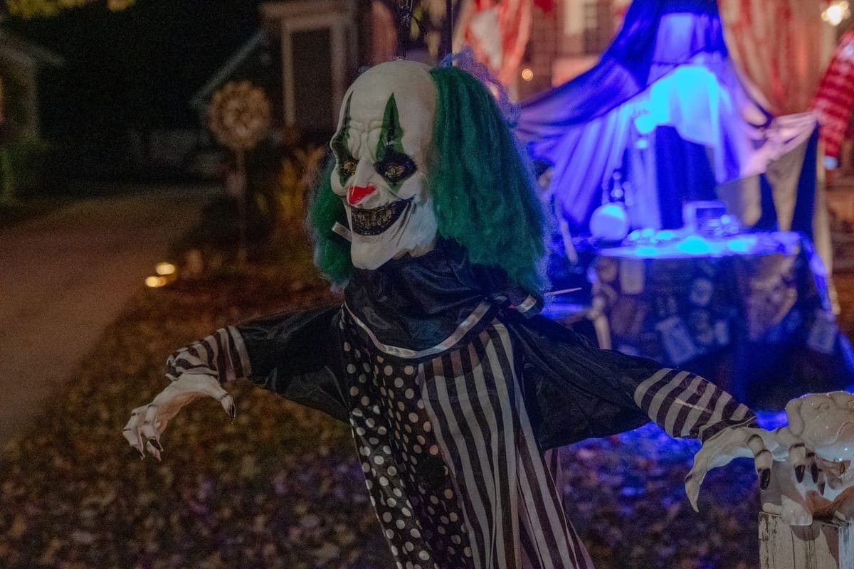 Two lit Halloween figures standing at opposite sides of a dark yard