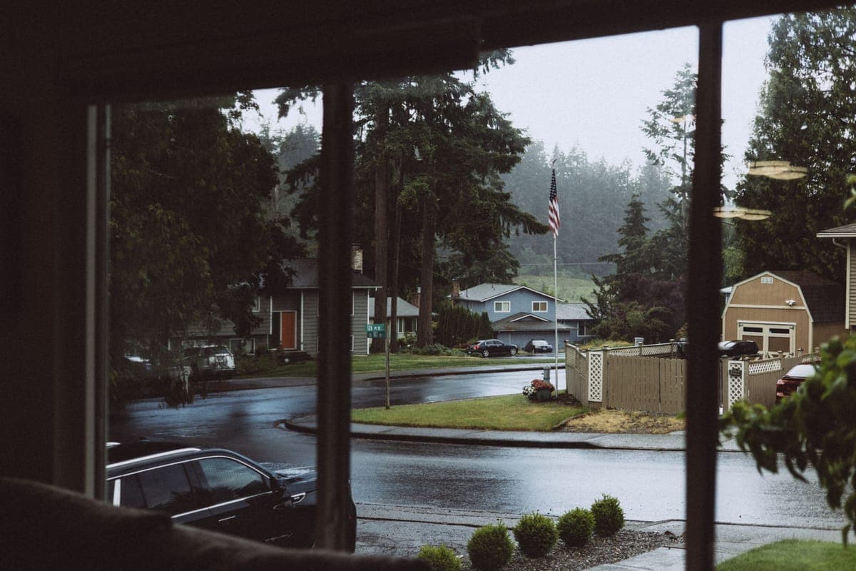 Rain falling across a decorated yard with a covered prop in the foreground