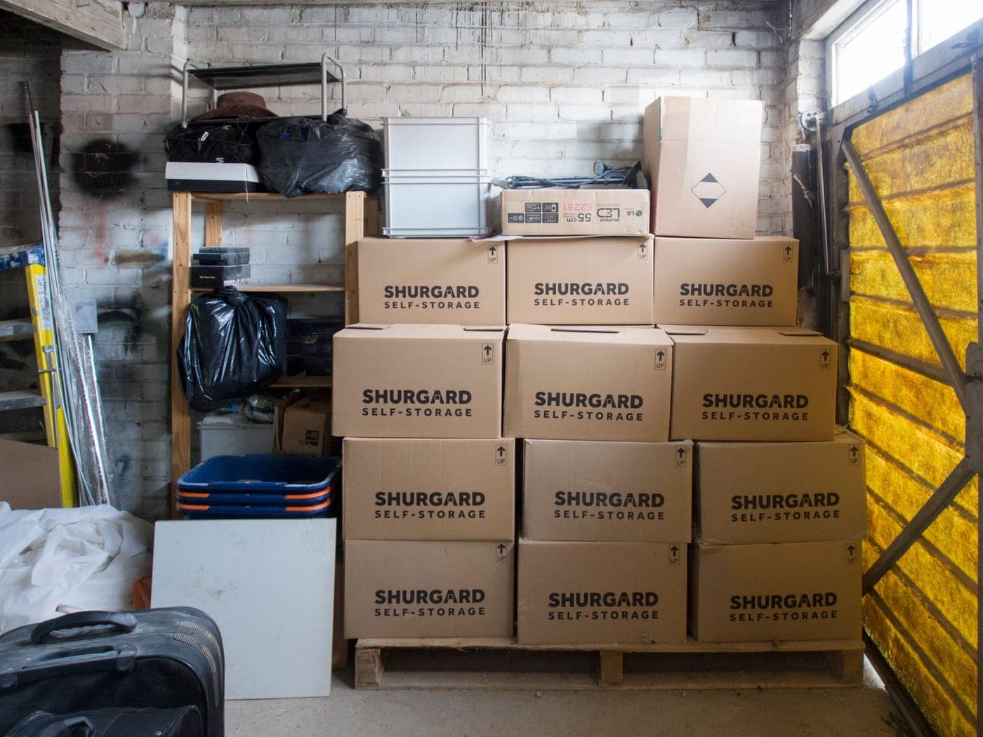 Labeled storage bins stacked on shelving in a garage