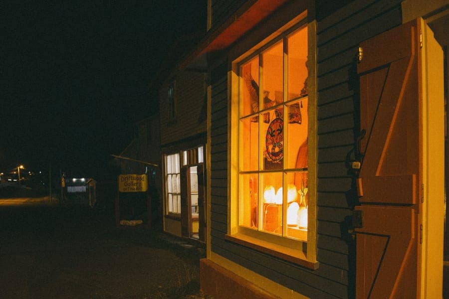A glowing inflatable shape emerging from an upper-floor window at night