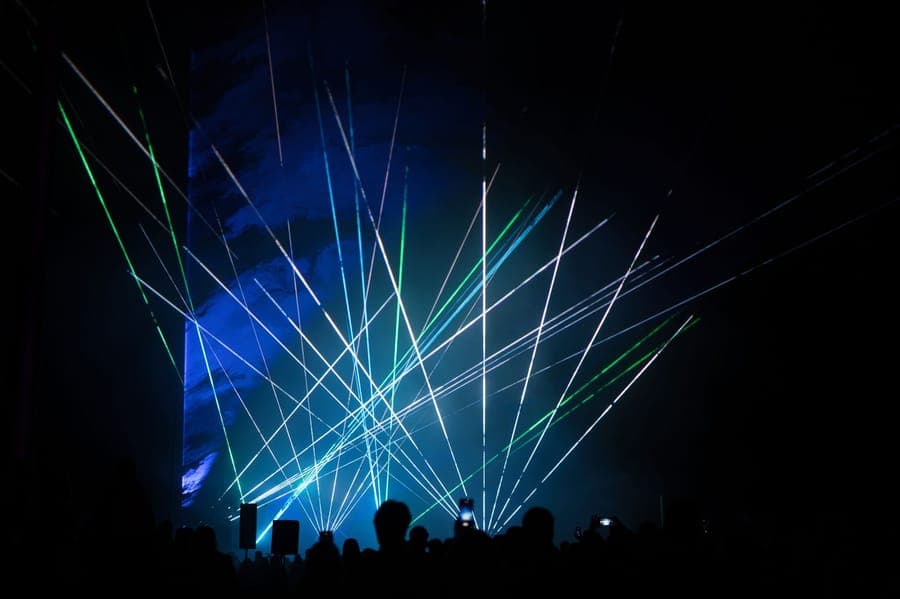 Points of green laser light scattered across a house facade