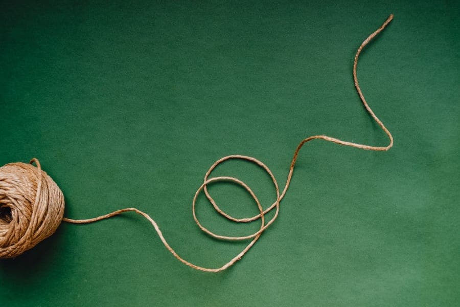 A thick orange extension cord coiled on a concrete garage floor