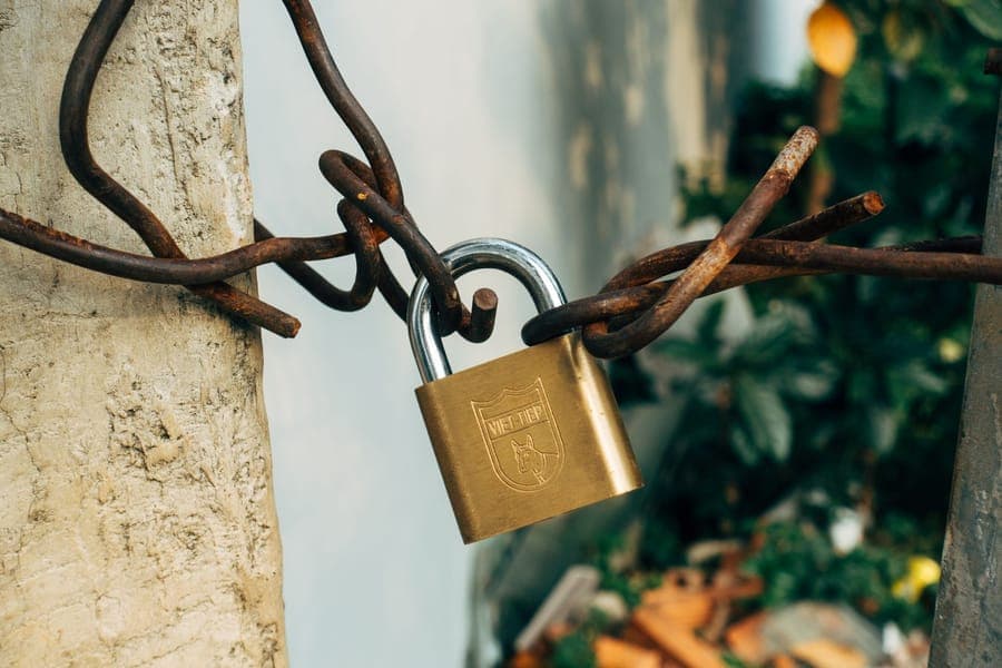 A steel cable looped around a post and secured with a padlock