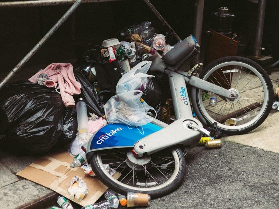 A tall wheeled storage bag standing in the corner of a garage